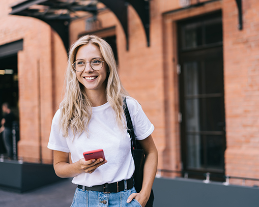 Glad tjej som håller sin telefon